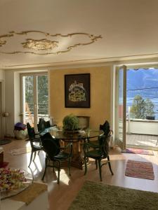 ein Wohnzimmer mit einem Tisch und Stühlen sowie einem Balkon in der Unterkunft BnB122 bed&breakfast in Ascona