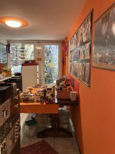 una cucina con parete arancione e tavolo in legno di BnB122 bed&breakfast ad Ascona