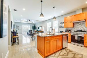 a kitchen with wooden cabinets and a large counter top at Tampa Home with Fire Pit, Grill, Cornhole and More! in Tampa
