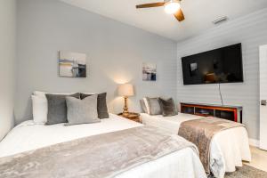 1 dormitorio con 2 camas y TV de pantalla plana en Tampa Home with Fire Pit, Grill, Cornhole and More! en Tampa