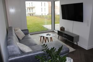 a living room with a couch and a flat screen tv at Nautica Bliss in Giżycko