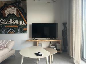 a living room with a tv and a white table at VILLA ANDERR in Sarandë
