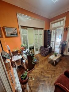 a living room with orange walls and a wooden floor at Aires de Tango Hostel in Buenos Aires