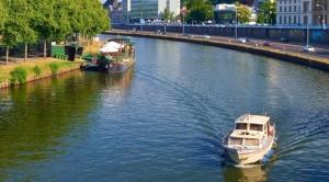 two boats on a river with a city in the background at Living at Saarpartments -AdultsOnly- 2 Bedrooms, Kitchen- Business & Holiday Apartments for Long- and Short term Stay, 3 min to Train-Station, Secure E-Bike Parking! in Saarbrücken