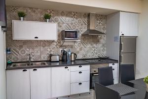 a kitchen with white cabinets and a sink at El Puente Holiday Home I- Airport 8,1K in Ingenio
