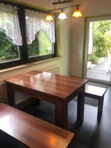 a wooden table in a room with two windows at Ferienwohnung Linda1 in Gunzenhausen