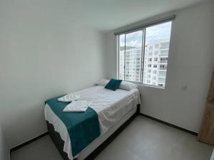 Habitación pequeña con cama y ventana en Apartamento con hermosa vista Piso 8, en Girardot
