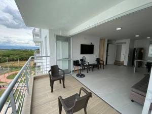 Habitación con balcón con sillas y TV. en Apartamento con hermosa vista Piso 8, en Girardot