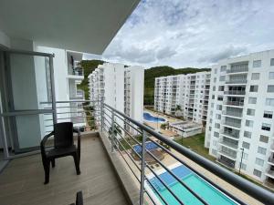 balcón con silla y vistas a la piscina en Apartamento con hermosa vista Piso 8, en Girardot