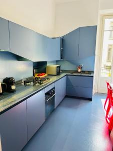 a kitchen with blue cabinets and a stove top oven at Maya Rooms in Milan