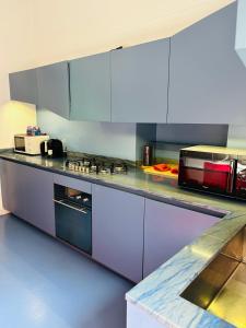 a kitchen with purple cabinets and a counter top at Maya Rooms in Milan