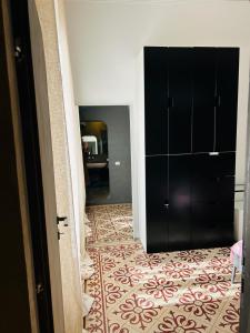 a hallway with a black cabinet and a carpet at Maya Rooms in Milan