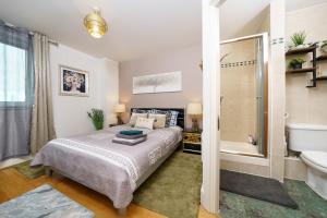 a bedroom with a bed and a tub and a sink at St George Thames Apartment in London