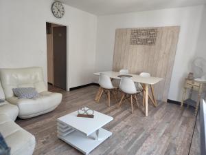 a living room with a couch and a table at La Maison CANTHEZ Wifi in Sigean