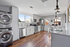 uma cozinha com armários brancos e electrodomésticos de aço inoxidável em Spectacular Roof Top Deck - Luxury 3 bedroom em Nova Orleans
