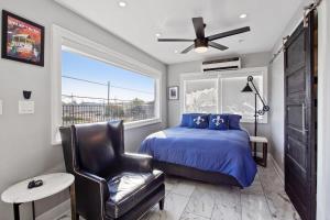 um quarto com uma cama, uma cadeira e uma janela em Spectacular Roof Top Deck - Luxury 3 bedroom em Nova Orleans