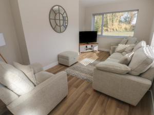 a living room with two chairs and a television at Wychwood in Haverfordwest