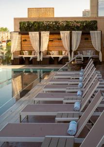 a row of lounge chairs sitting next to a swimming pool at The Fontaine in Kansas City