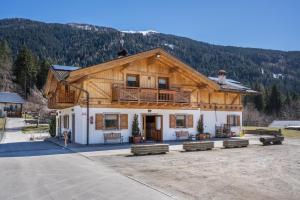 a large wooden house with a balcony on top of it at Chalet Camping Faè 3 in Madonna di Campiglio