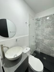 La salle de bains est pourvue d'un lavabo, de toilettes et d'une douche. dans l'établissement HOTEL LE QUINT, à Cúcuta