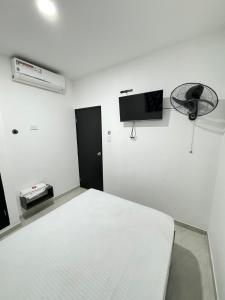 um quarto branco com uma cama e uma televisão na parede em HOTEL LE QUINT em Cúcuta