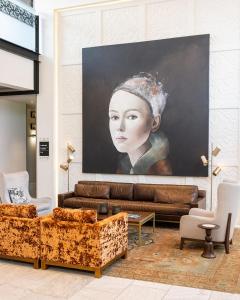 a living room with a painting of a woman at The Fontaine in Kansas City