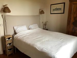 - une chambre avec un lit blanc et une table de nuit dans l'établissement Etape dans le Berry, à Coings