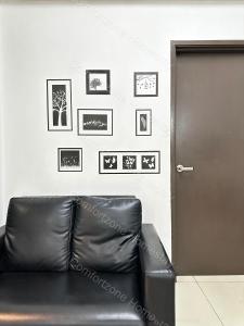 um sofá de couro preto em frente a uma porta em ComfortZone Homestay 3 em Ipoh