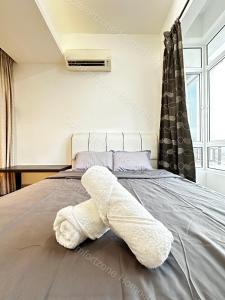 um urso de peluche branco deitado numa cama em ComfortZone Homestay 3 em Ipoh