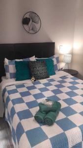 ein Schlafzimmer mit einem blauen und weißen Bett mit Kissen in der Unterkunft Elegance Suítes Anhembi in São Paulo