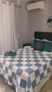 een blauw en wit geruit bed in een slaapkamer bij Elegance Suítes Anhembi in Sao Paulo