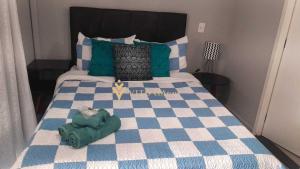 Schlafzimmer mit einem Bett mit blau-weißer Bettwäsche in der Unterkunft Elegance Suítes Anhembi in São Paulo