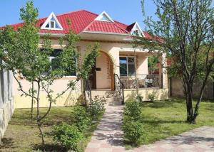 a small yellow house with a red roof at Qabala_Renting_houses near the mountain in Gabala