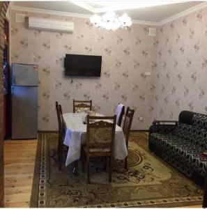a dining room with a table and a couch at Qabala_Renting_houses near the mountain in Gabala