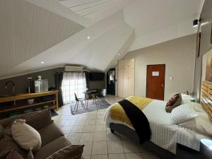 - une chambre avec un lit et un canapé dans l'établissement Echo Mountain Inn, à Thabazimbi
