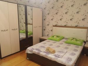 Un dormitorio con una cama con almohadas verdes. en Qabala_Renting_houses near the mountain en Gabala