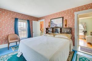 een slaapkamer met een wit bed in een kamer met behang bij Spacious Round Pond House with On-Site Trail Access! in Round Pond