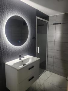 a bathroom with a white sink and a mirror at Domek MajAmi in Turawa