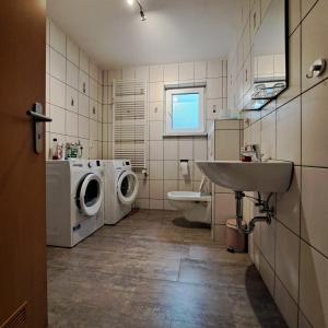 a bathroom with a washing machine and a sink at Fewo-Hengesbach in Much