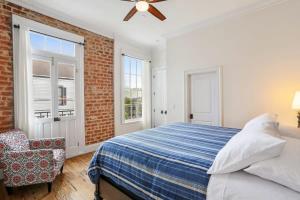 a bedroom with a bed and a brick wall at The Burgundy House #1 Steps to the French Quarter in New Orleans