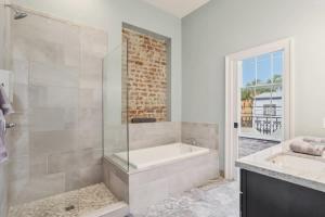 a white bathroom with a tub and a sink at The Burgundy House #1 Steps to the French Quarter in New Orleans +19 photos