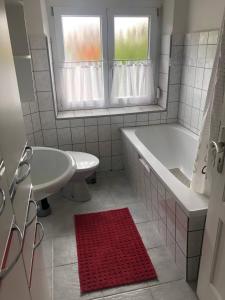 a white bathroom with a tub and a sink at Ferienwohnung Linda1 in Gunzenhausen