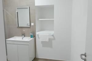 uma casa de banho branca com um lavatório e um espelho em Apartment in Semeador 1 em Portalegre