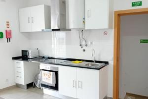 una cocina con armarios blancos y fregadero en Apartment in Semeador 1, en Portalegre