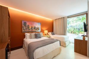 a hotel room with two beds and a window at Casa 3A Tivoli Ecoresidences in Praia do Forte