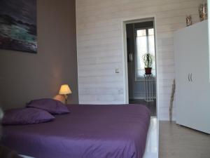 una camera con letto viola e finestra di Les Flots Bleus a Andernos-les-Bains