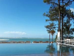 a swimming pool with a view of the ocean at Les Flots Bleus in Andernos-les-Bains