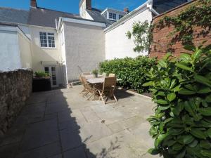 a patio with a table and chairs next to a building at Laurel Cottage in Exmouth
