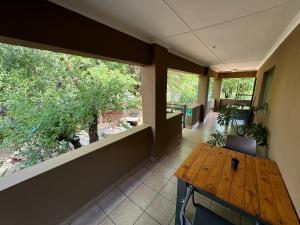an empty room with a wooden table and windows at Echo Mountain Inn in Thabazimbi