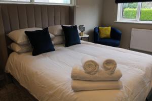 a bedroom with a bed with towels on it at 4 Bedroom Getaway New Forest in New Milton